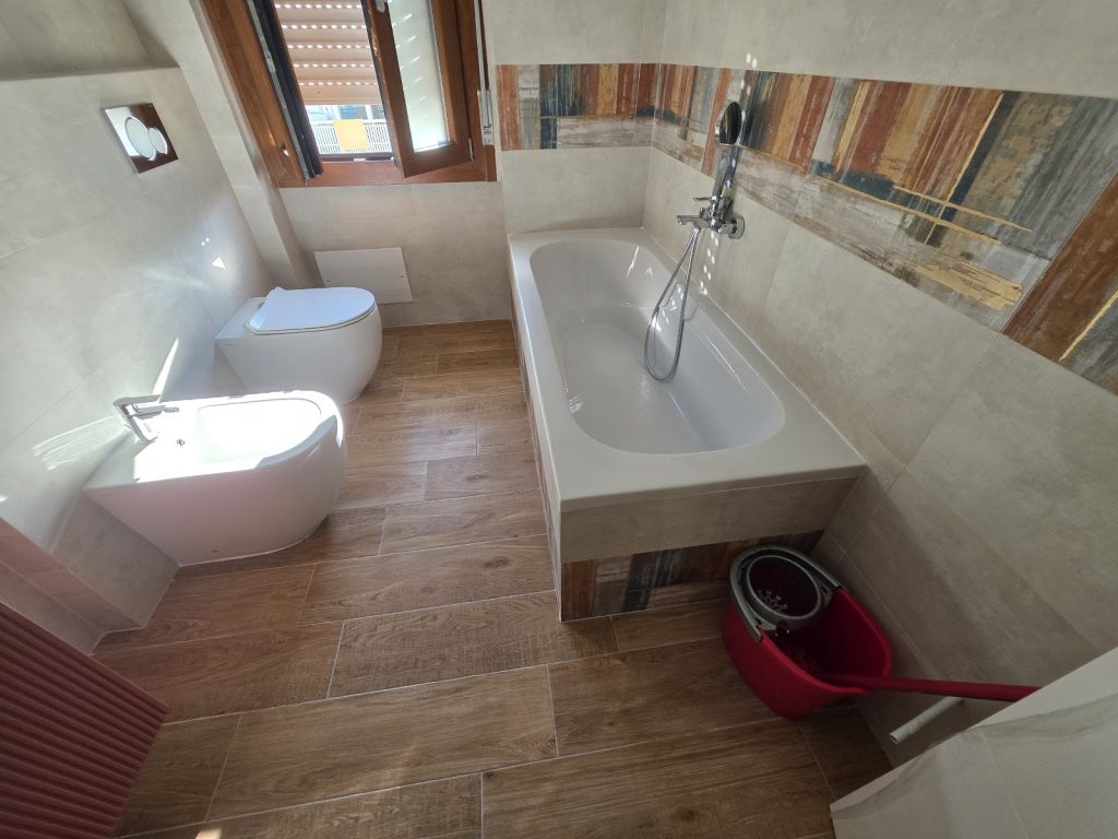 Bagno con vasca, finestra e sanitari
